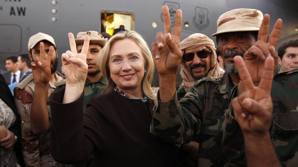 Secretary of State Hillary Clinton stands with Libyan fighters who ousted Moammar Gadhafi during an Oct. 18, 2011, visit to Libya. On Wednesday, she is to testify on the attack that killed four Americans in Benghazi last September.
