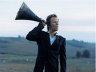 Tom Waits with a megaphone to his ear. Tom Waits with a megaphone to his ear.