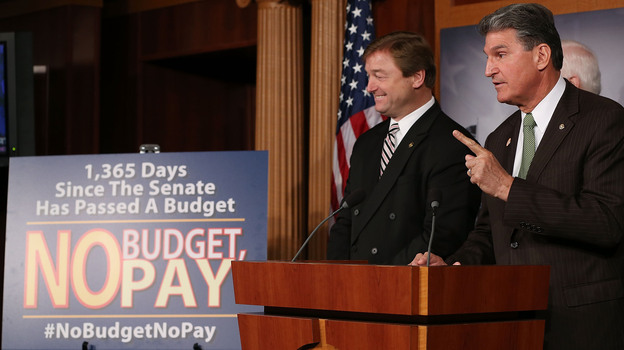 Sen. Dean Heller (left), R-Nev., and Sen. Joe Manchin, D-W.Va., speak Wednesday at the U.S. Capitol about legislation to delay a potential clash over the debt ceiling until May — and to freeze the paychecks of lawmakers if they don't pass a budget resolution.