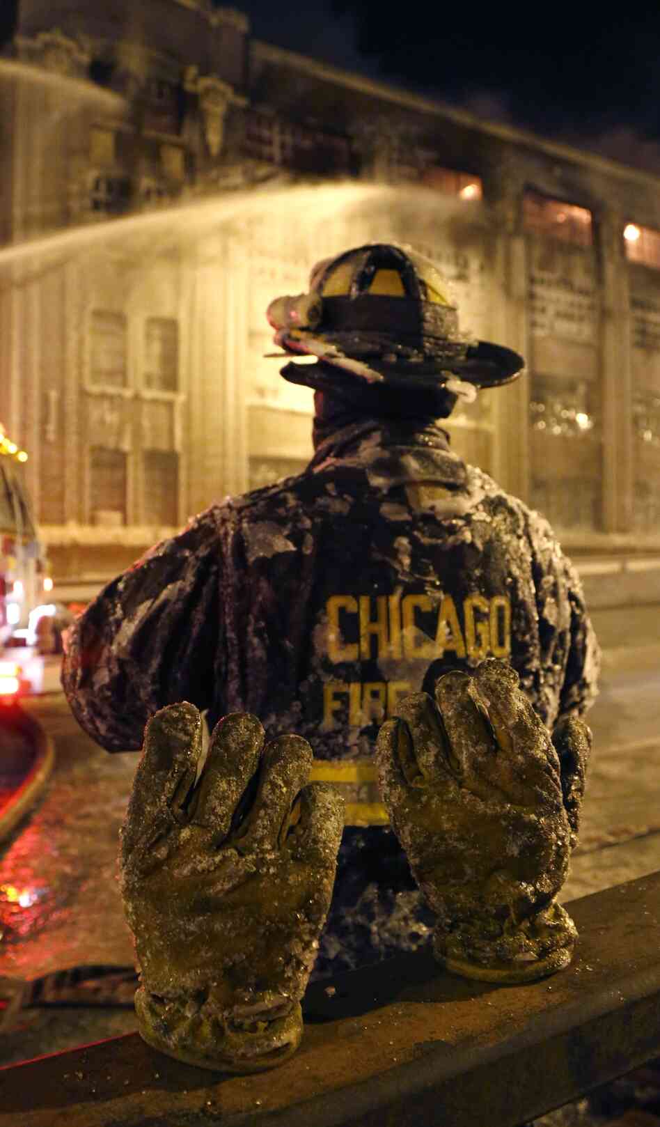 A frozen pair of gloves belonging to a Chicago firefighter stand on a railing behind him, during a five-alarm blaze in a warehouse on the city's South Side. A frozen pair of gloves belonging to a Chicago firefighter stand on a railing behind him, during a five-alarm blaze in a warehouse on the city's South Side.