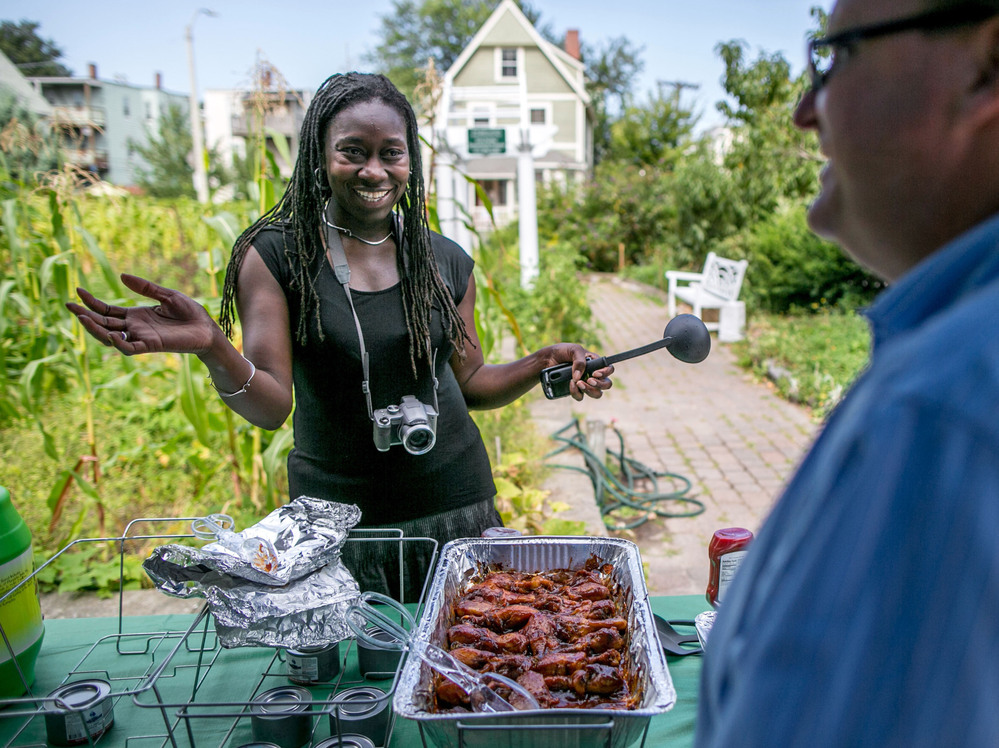 Jhana Senxian, head of the Coleman Street Association, serves food during a block party.