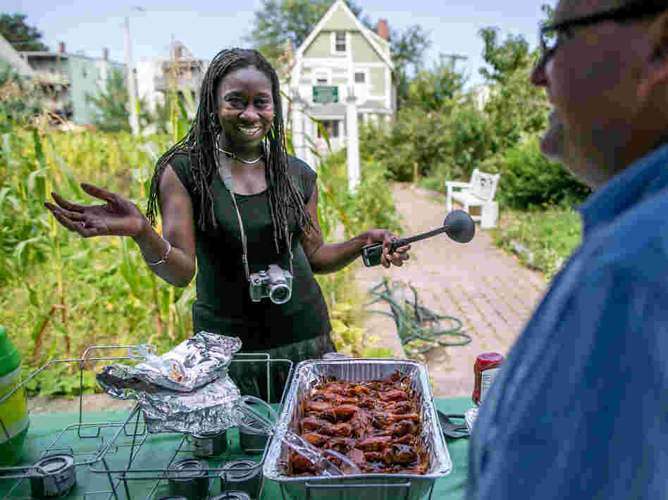 Jhana Senxian, head of the Coleman Street Association, serves food during a block party.