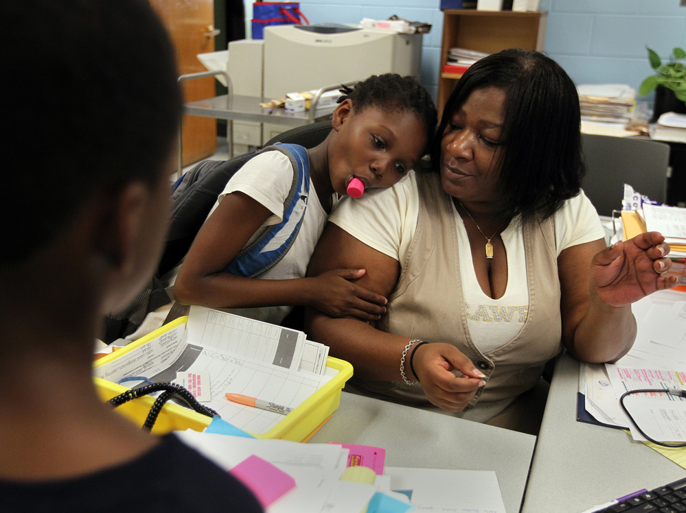 Theresa Johnson gets a hug from first-grader Shaundene Funches on the last day of the year at Marshall Elementary School in Dorchester, Mass.