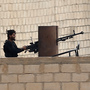 A Syrian rebel fighter in the northeastern Syrian border town of Ras al-Ayn on Nov. 11. The rebels and a Kurdish militia in the town both oppose President Bashar Assad's regime, but they have been fighting each other in recent days. A Syrian rebel fighter in the northeastern Syrian border town of Ras al-Ayn on Nov. 11. The rebels and a Kurdish militia in the town both oppose President Bashar Assad's regime, but they have been fighting each other in recent days.