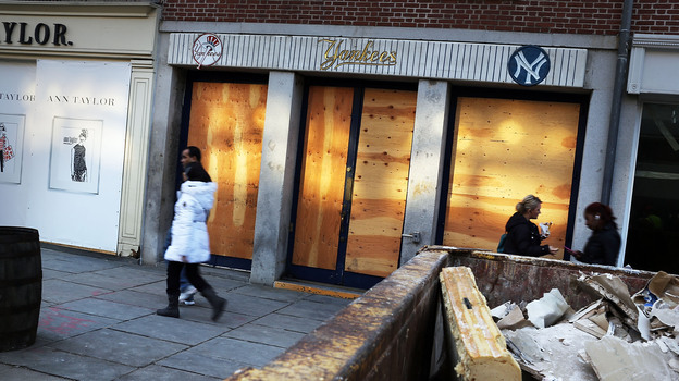 People walk past a closed business affected by Hurricane Sandy in the heavily damaged South Street Seaport in New York City in December.