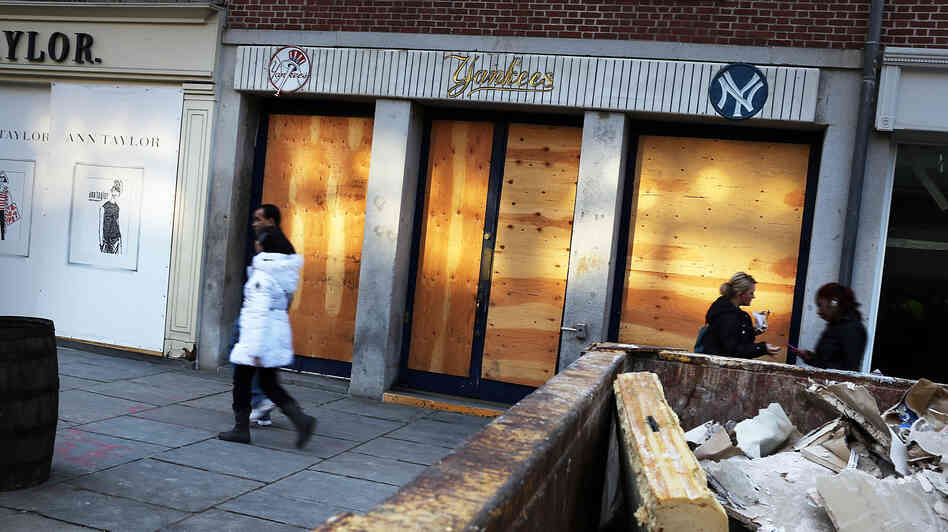 People walk past a closed business affected by Hurricane Sandy in the heavily damaged South Street Seaport in New York City in December.