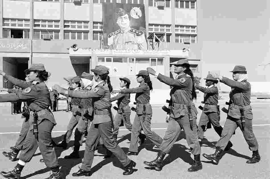 Female soldiers with AK-47 rifles and bayonets march on the parade grounds at the Women's Military Academy in Tripoli, Libya, on Jan. 18, 1986. At rear is a portrait of of Libyan ruler Moammar Gadhafi.
