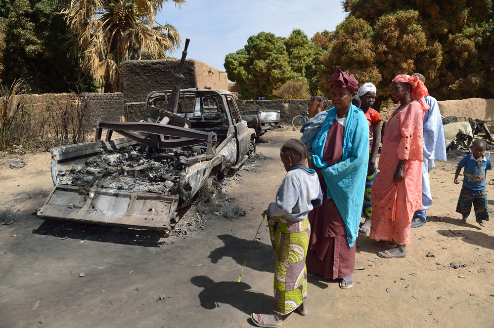 Malians gather around the remains of vehicles used by Islamist rebels that were destroyed by an earlier French airstrike, Jan. 23 in Diabaly, about 250 miles north of Bamako, Mali's capital.