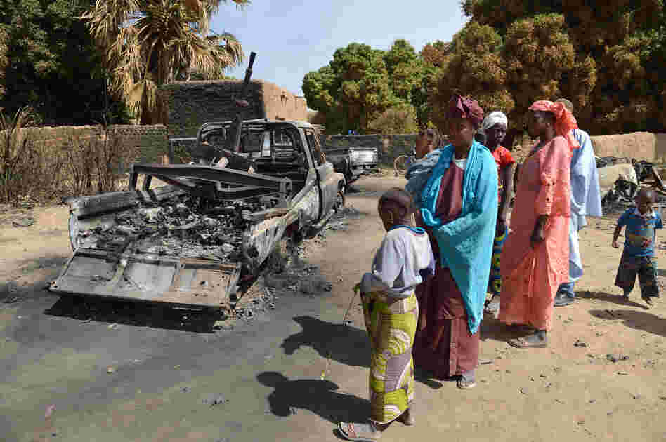 Malians gather around the remains of vehicles used by Islamist rebels that were destroyed by an earlier French airstrike, Jan. 23 in Diabaly, about 250 miles north of Bamako, Mali's capital.