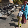 Malians gather around the remains of vehicles used by Islamist rebels that were destroyed by an earlier French airstrike, Jan. 23 in Diabaly, about 250 miles north of Bamako, Mali's capital.