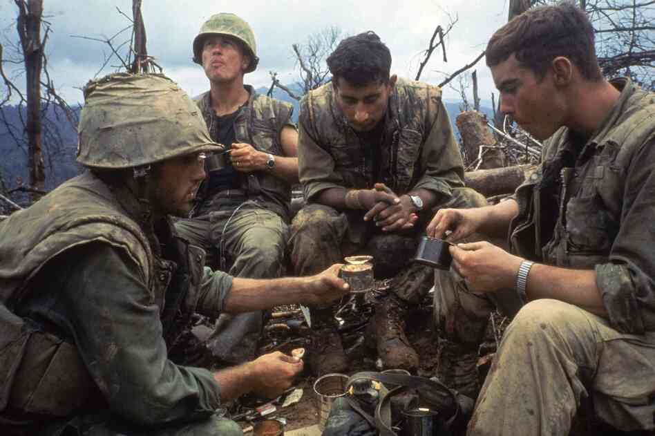 American Marines eat rations during a lull in the fighting near the Demilitarized Zone during the Vietnam War, October 1966.