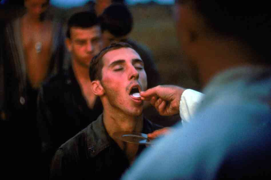American Marines receive the sacrament of Communion during a lull in the fighting near the Demilitarized Zone during the Vietnam War, October 1966.