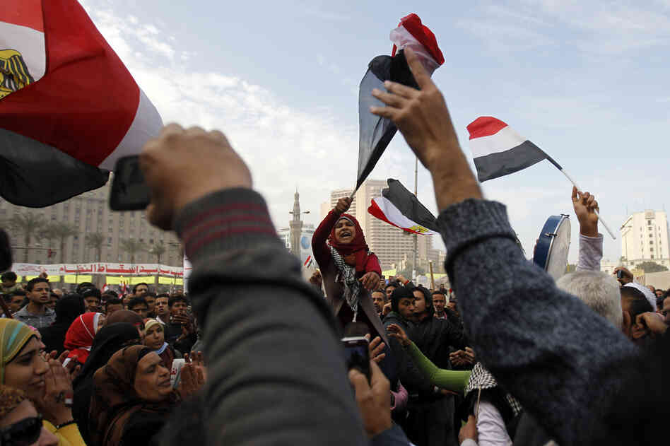Egyptian demonstrators wave the national flag and shout slogans during a protest in Tahrir Square on January 25, 2013 in Cairo.
