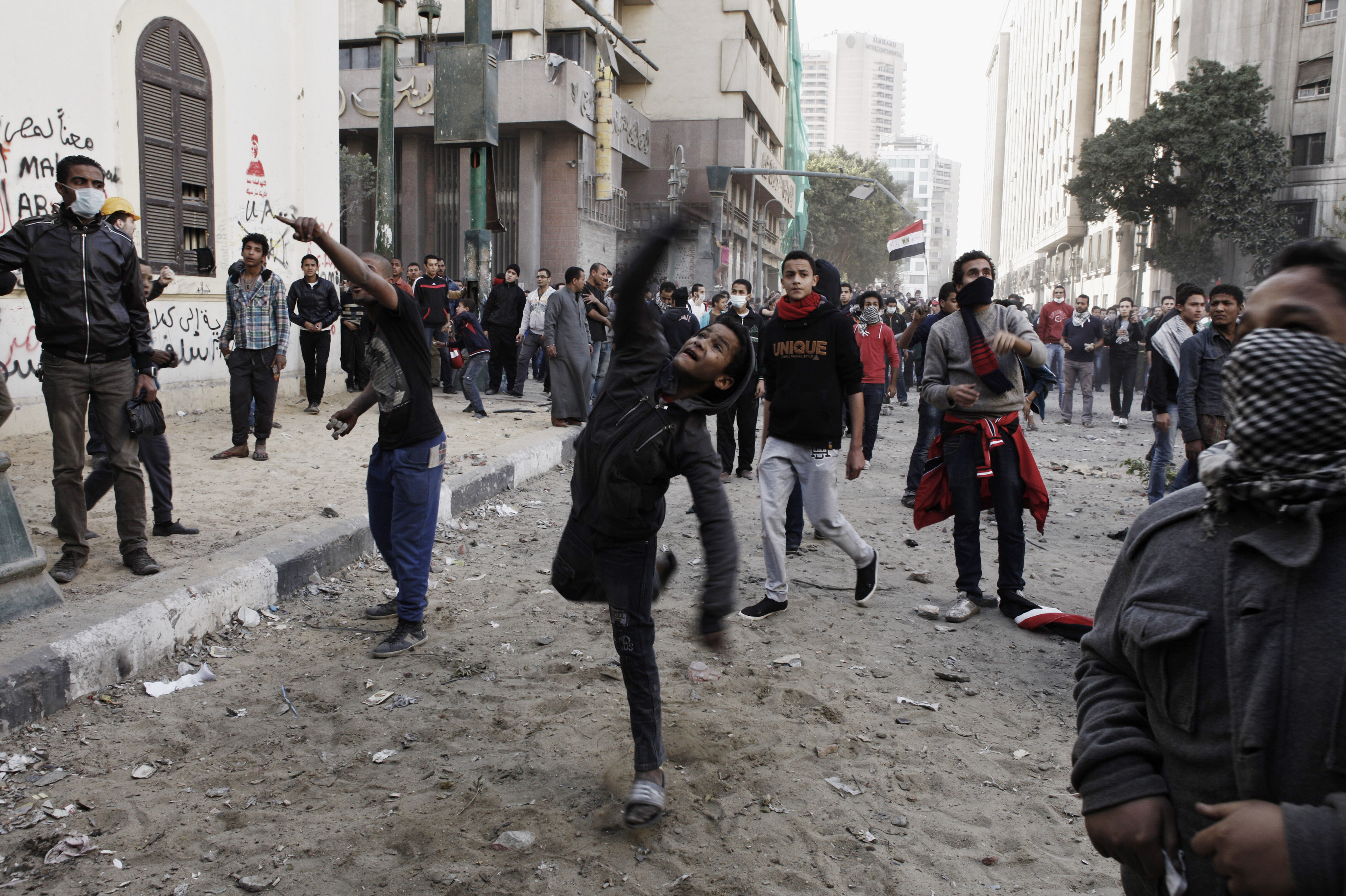 An Egyptian protester throws a rock toward riot police during a demonstration in Tahrir Square on January 25, in Cairo, Egypt.