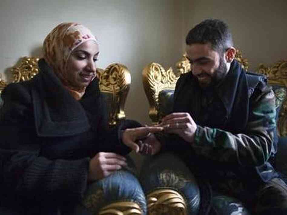Yusef puts a wedding ring on his fiancee Ghada's finger in the war-torn city of Aleppo in northern Syria on Jan. 17. They met on Facebook and were wed by a rebel commander. Yusef puts a wedding ring on his fiancee Ghada's finger in the war-torn city of Aleppo in northern Syria on Jan. 17. They met on Facebook and were wed by a rebel commander.