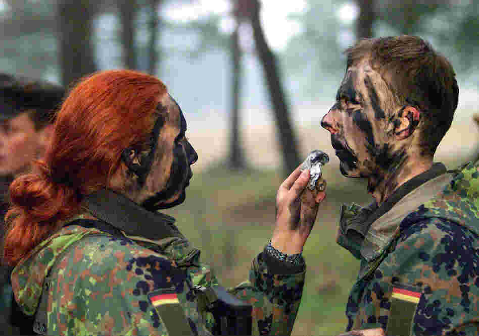 Private Dajana Bartczewski (left) puts camouflage paint on the face of a male soldier during an exercise by German Bundeswehr soldiers from the barracks in Augustdorf, western Germany, on Jan. 9, 2001.