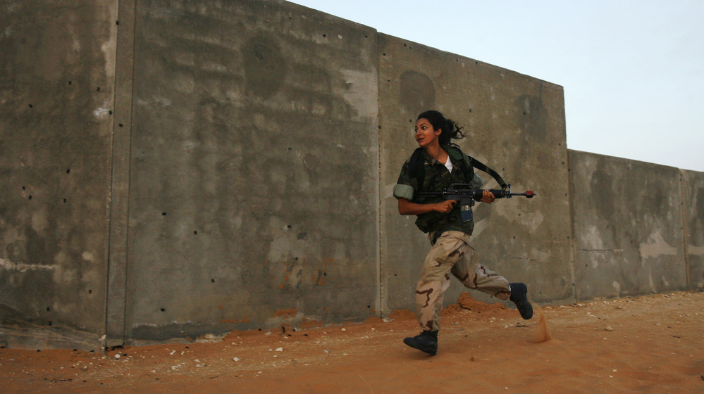 A female Israeli soldier runs during an urban warfare exercise at an army training facility near Zeelim, Israel, on June 19, 2008.