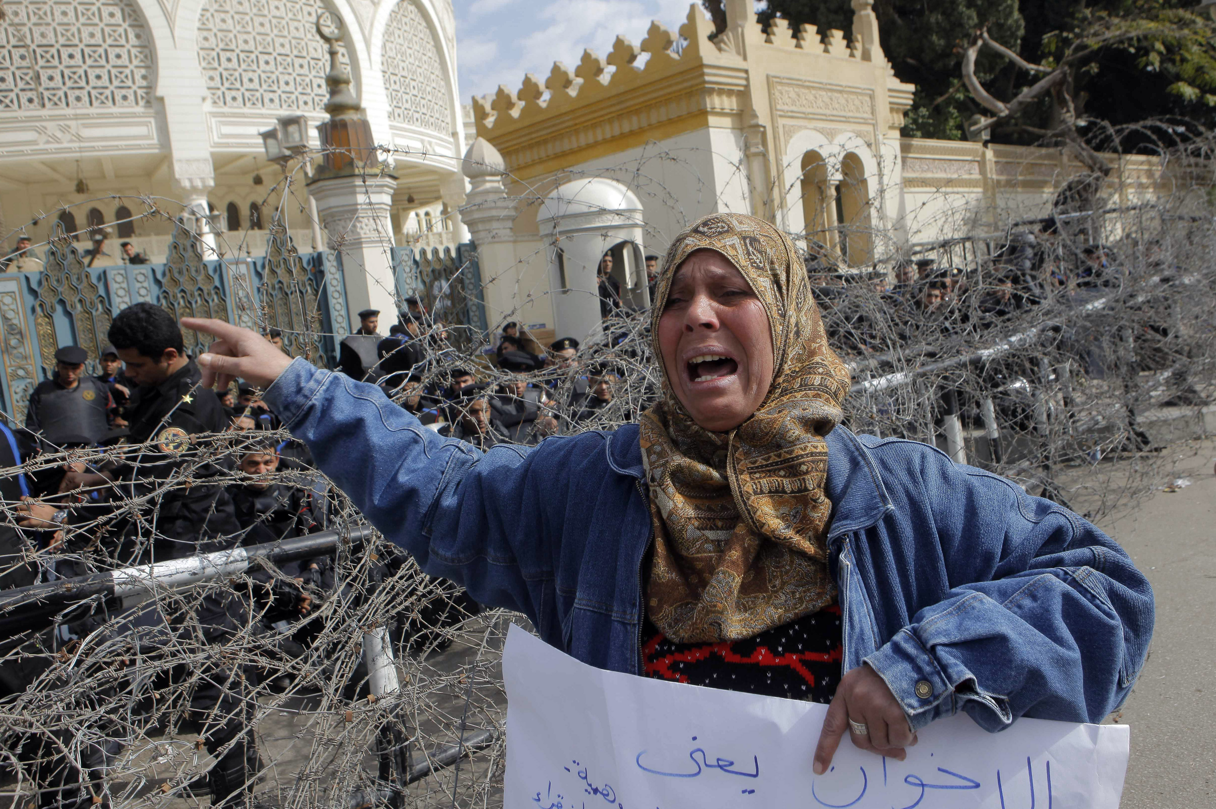 An Egyptian protester shouts anti-President Morsi slogans as anti-riot forces block the entrance to the presidential palace in Cairo, Egypt, Friday, Jan.25, 2013.