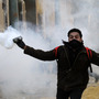 An Egyptian protester runs to throw tear gas during a protest in Tahrir Square on January 25, 2013 in Cairo.