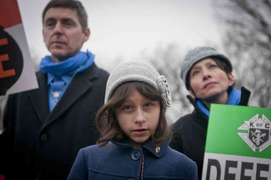 Lucia Dragas, 8, from Boston, Mass., held a poster saying "Defend Life" along with her parents during the rally.