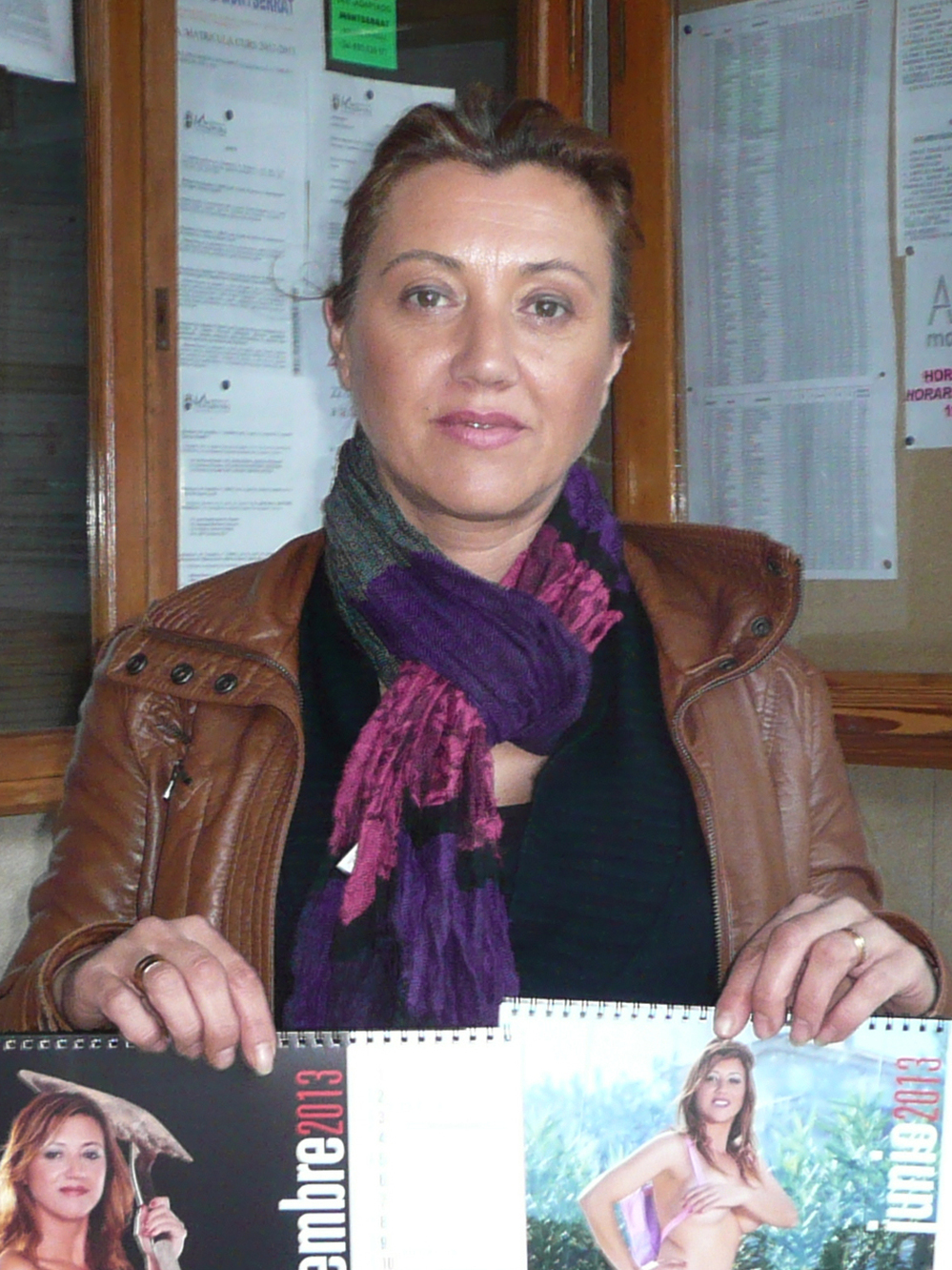 Eva Maria Casas Sancho — Ms. June — shows off the racy calendar. The calendar has raised enough money to pay for three months of school bus service.