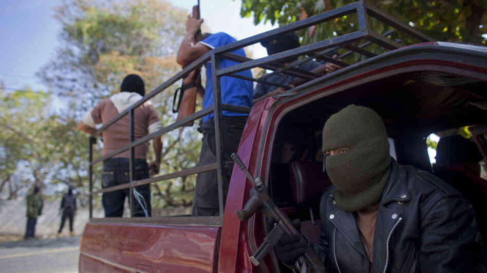 Masked and armed men guard a roadblock near the town of Ayutla, Mexico, on Jan. 18. Hundreds of men in the southern Mexican state of Guerrero have taken up arms to defend their villages against drug gangs.