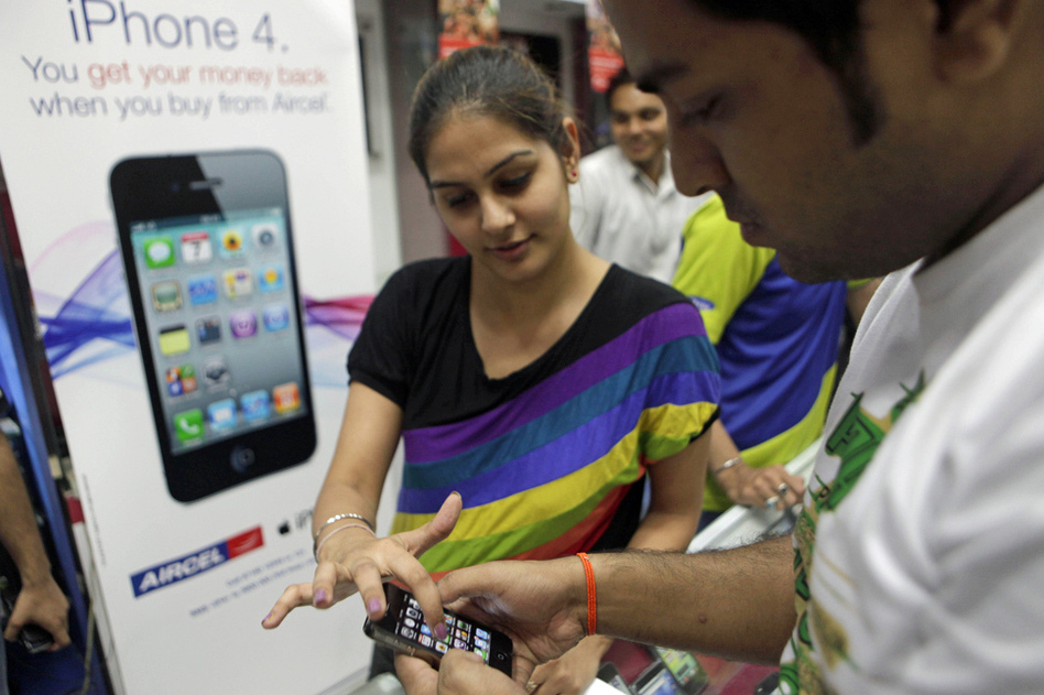 A salesperson demonstrates the Apple iPhone 4 in New Delhi, India. While mobile device use is growing rapidly in emerging markets, Apple's current product line may prove prohibitively expensive for many consumers.