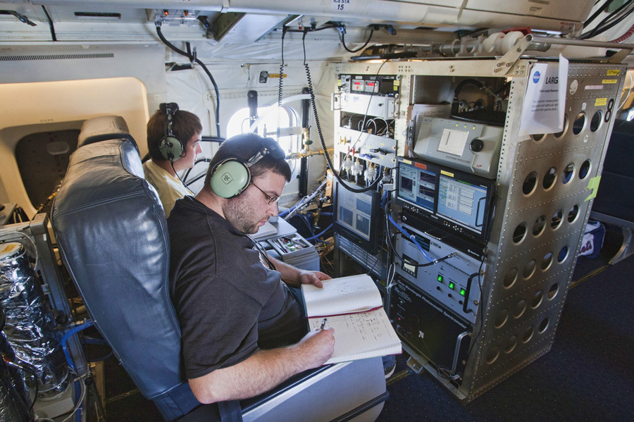 Terry Lathem, a graduate student in Georgia Tech's School of Earth and Atmospheric Sciences, takes notes aboard a NASA DC-8 aircraft gathering samples of microorganisms in the atmosphere. (Image credit: NASA)