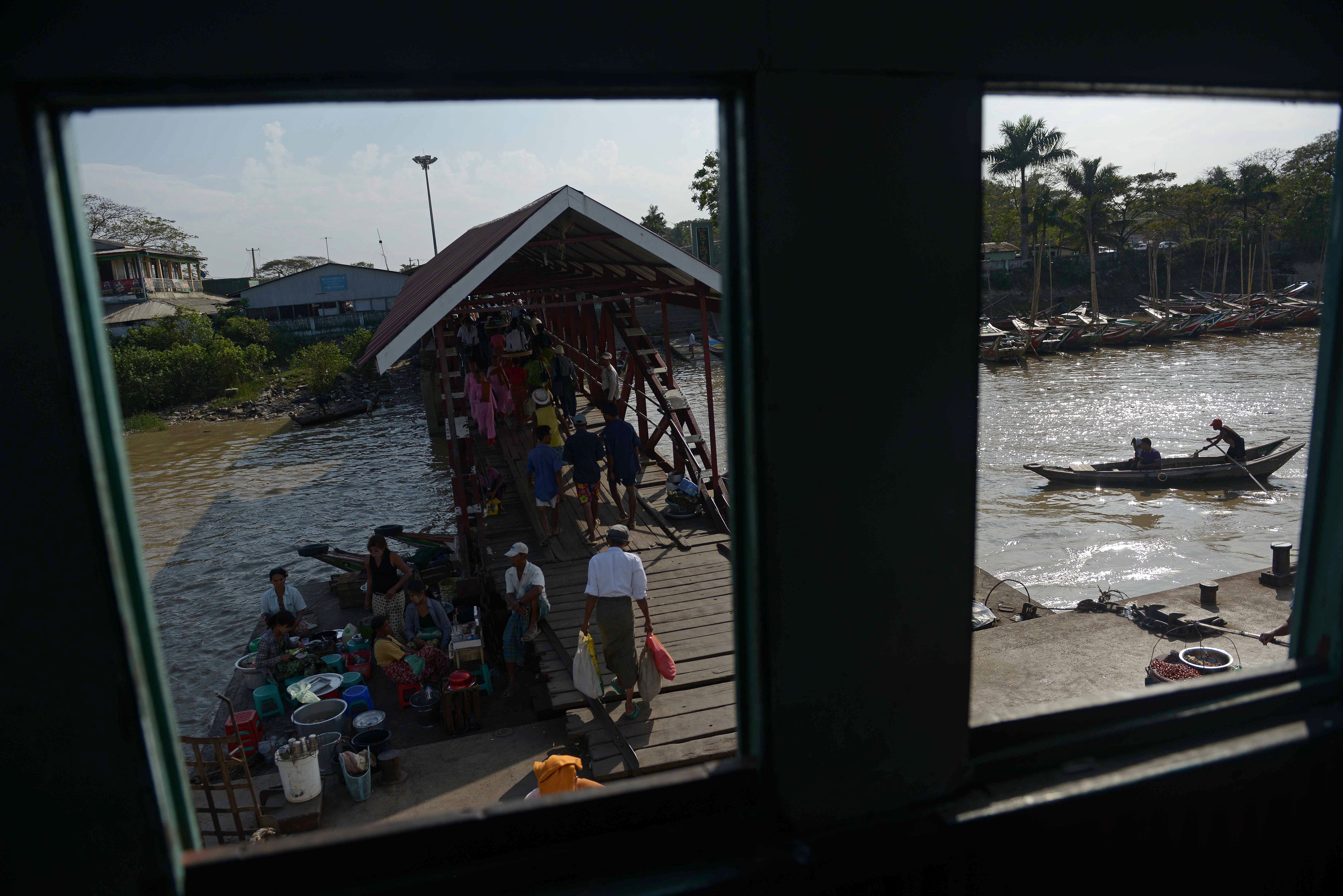 Food vendors wait for customers at a ferry pier in Yangon on January 28.