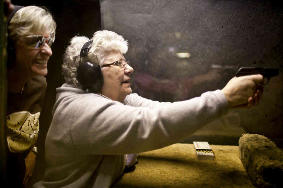 Renee Blaine (left), a member of the women's shooting league A Girl and A Gun, gives Delores Mouton, 75, tips on how to fire a gun during a "girls' night out" event at the Eagle Peak Shooting Range in Leander, Texas. Mouton had never shot a gun before this evening, but hit a bull's-eye her first time. She says she is learning to shoot for personal protection.