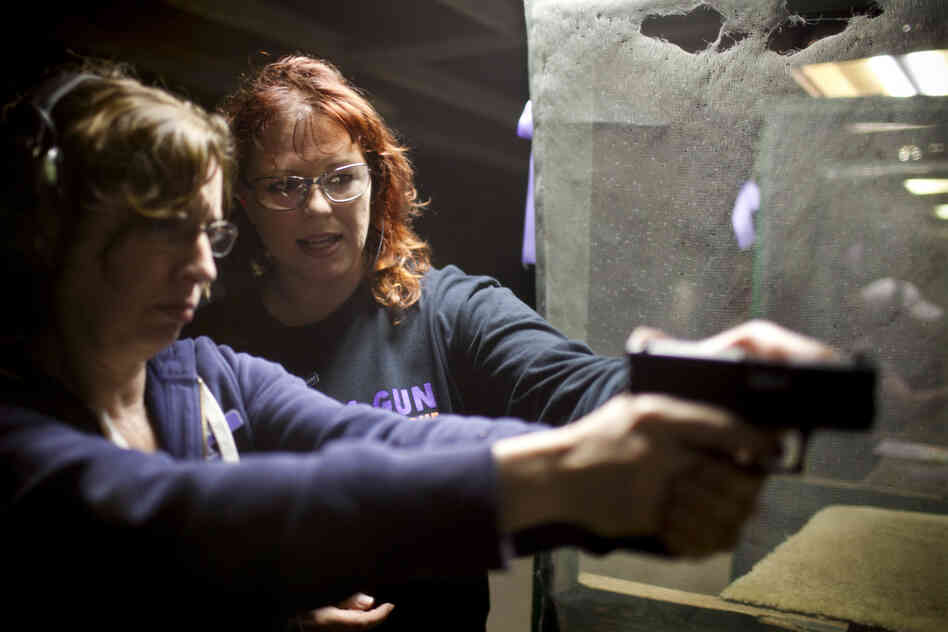 Crowder (right) helps Maria Acosta, a new league member, fire her weapon. Acosta, who has a concealed-weapons permit, joined the league to feel more confident in her shooting in order to protect her home. She says being around the other women makes her feel sure of herself, and not "silly."
