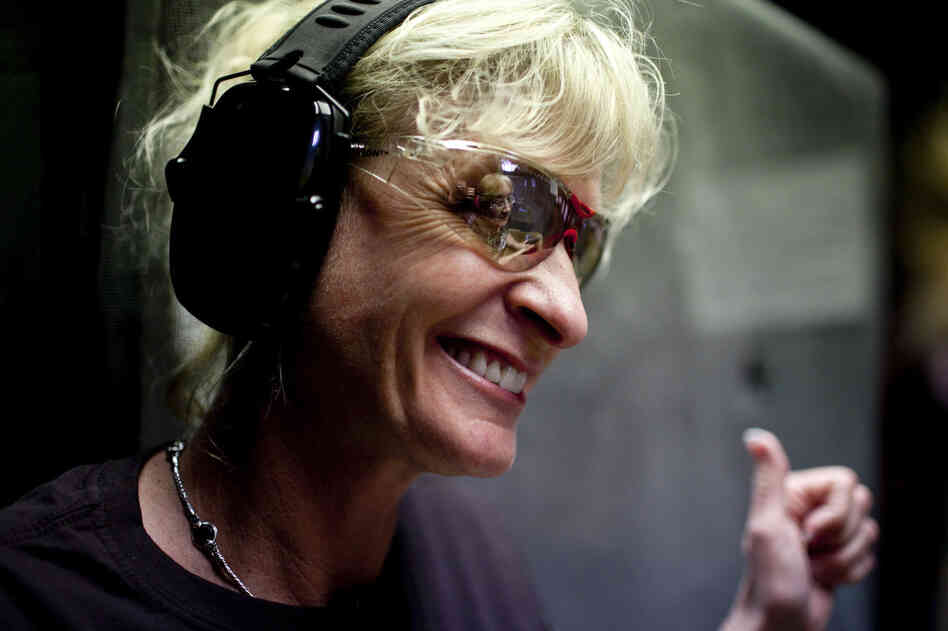 Blaine smiles while giving pointers on technique to Courtney Bird (reflected in glasses). The women in the group go out to dinner after their time at the range to socialize.