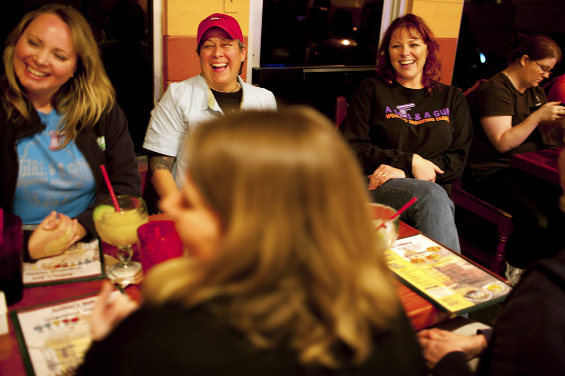 Shooting range instructor Julianna Crowder (second from right) has dinner with fellow members of the shooting league A Girl and A Gun, in Leander, Texas.