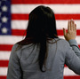 A woman takes the oath of allegiance during a naturalization ceremony at the district office of the U.S. Citizenship and Immigration Services in Newark, N.J.