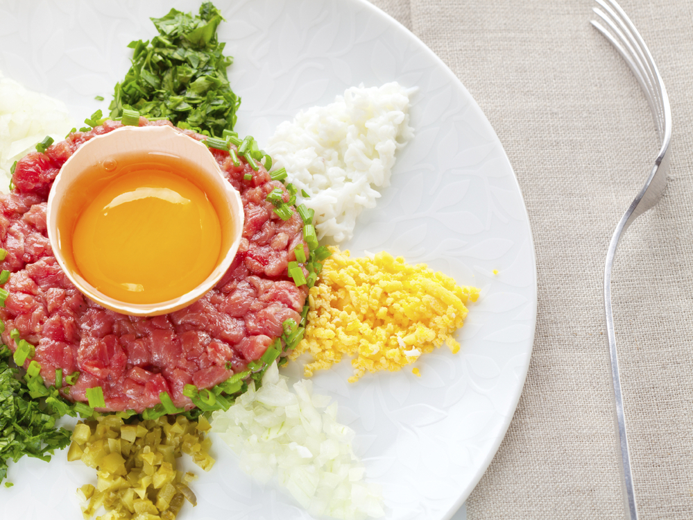 A traditional steak tartare with egg, onion and capers.