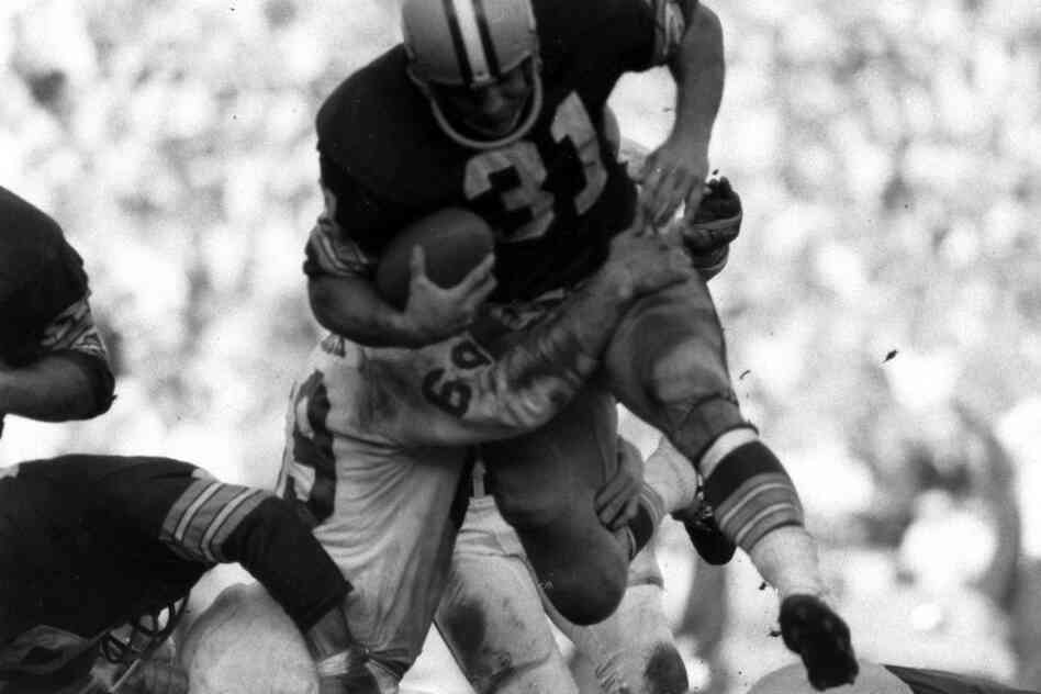 Green Bay Packer Jim Taylor is tackled by the Chiefs' Sherrill Headrick.
