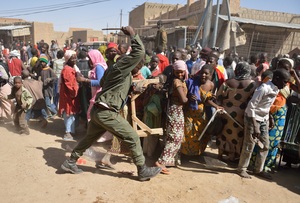 A Malian soldier tries to disperse looters in the streets of Timbuktu on Tuesday.