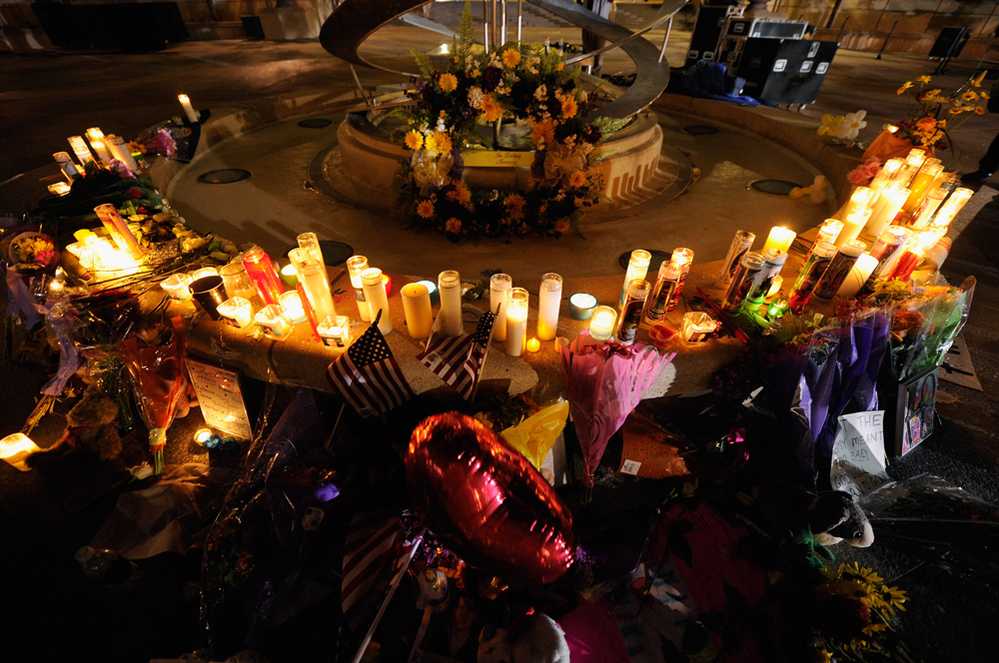 Mourners create a memorial at the fountain of the Aurora Municipal Center after a prayer vigil Sunday for the 12 victims of Friday's mass shooting at the Century 16 movie theater.