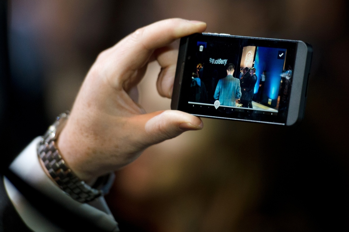 A member of the RIM team poses with one of the new touchscreen Z10 Blackberry devices.