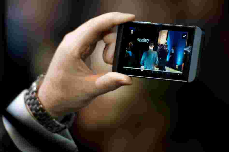 A member of the RIM team poses with one of the new touchscreen Z10 Blackberry devices.