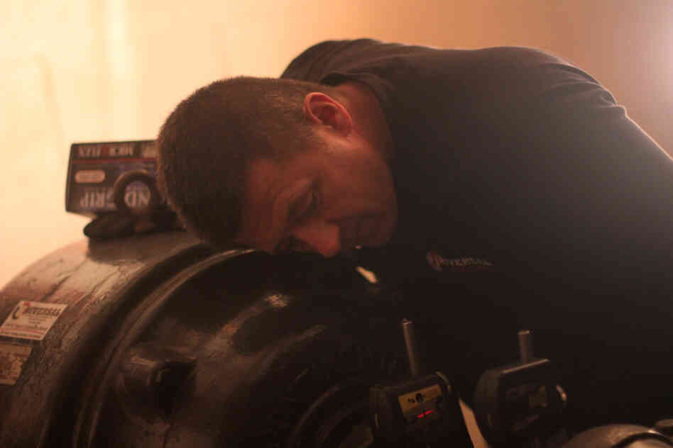 Mechanic Robert Sudo adjusts the motor of a powerful water pump that was knocked out by flooding.