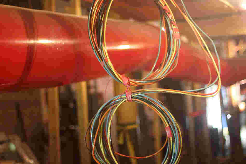 Electrical switching equipment has been moved out of this basement space to a ground floor area that used to hold an eyeglass shop. The large orange pipe is made of plastic sheeting, and air flows through to dehumidify the basement.