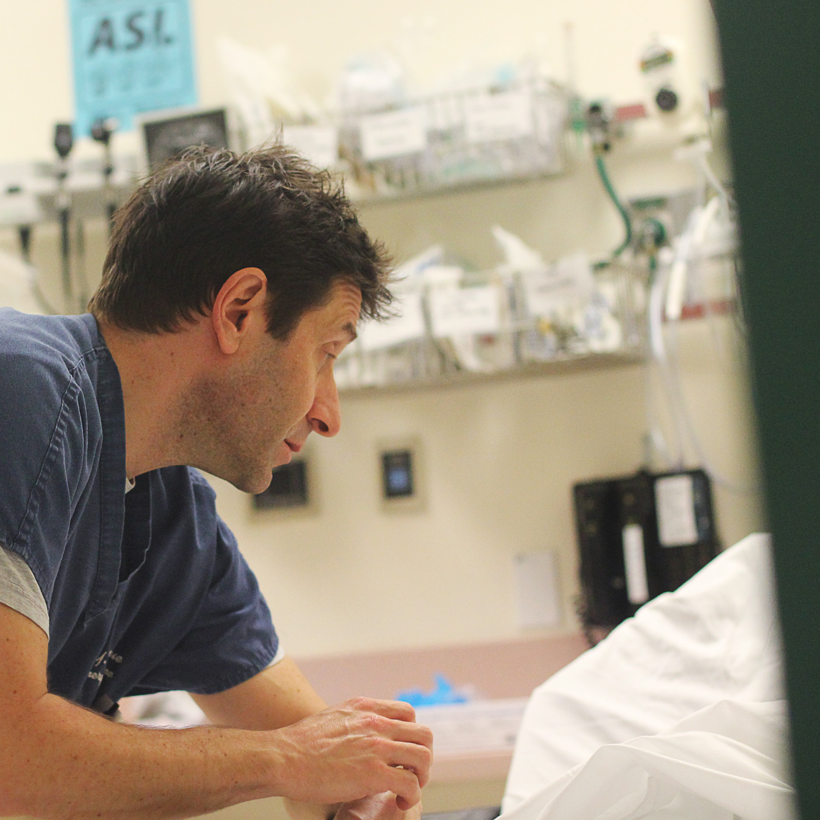 While repairs continue in the basement below, Dr. William Goldberg talks to a hospital patient who reports flu-like symptoms.