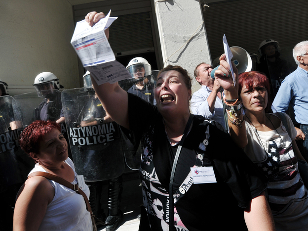 Unpaid for five months, nurse Paraskevi Petropoulou holds her unpaid electricity bill outside the Ministry of Health in Athens during an anti-government protest on Sept. 28, 2012.