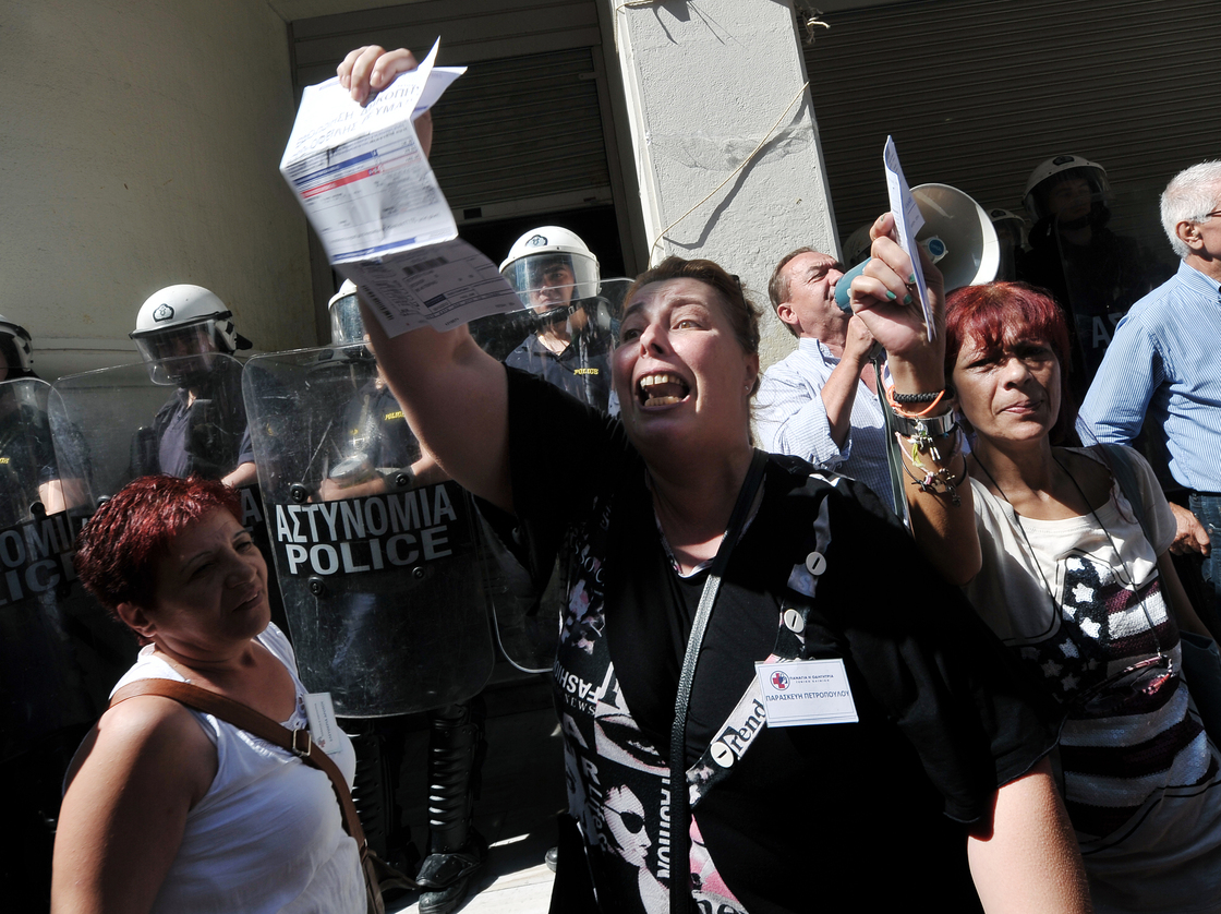 Unpaid for five months, nurse Paraskevi Petropoulou holds her unpaid electricity bill outside the Ministry of Health in Athens during an anti-government protest on Sept. 28, 2012.