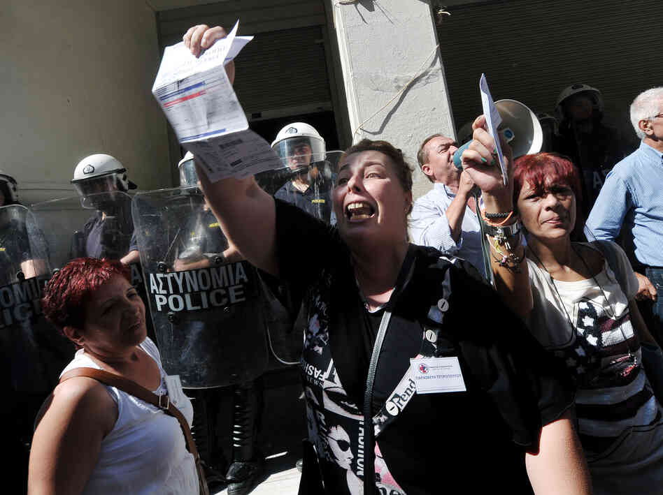 Unpaid for five months, nurse Paraskevi Petropoulou holds her unpaid electricity bill outside the Ministry of Health in Athens during an anti-government protest on Sept. 28, 2012.