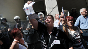Unpaid for five months, nurse Paraskevi Petropoulou holds her unpaid electricity bill outside the Ministry of Health in Athens during an anti-government protest on Sept. 28, 2012.