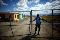 An armed guard keeps watch over a new, USAID-funded housing complex. The homes will be offered to people who work at Caracol.