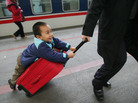 A boy hitches a ride on a suitcase as he waits to board a train at Beijing West Railway Station during Chunyun travel peak on Feb. 8, 2007. A boy hitches a ride on a suitcase as he waits to board a train at Beijing West Railway Station during Chunyun travel peak on Feb. 8, 2007.