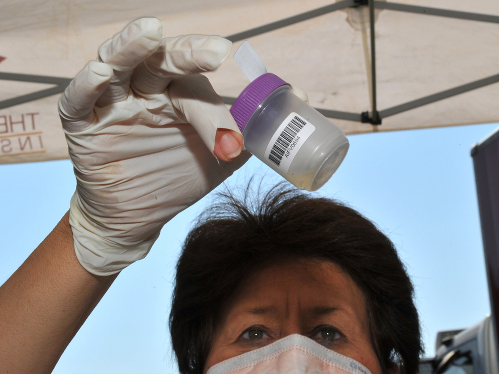 A medical worker in Carletonville, South Africa, examines a sample at a mobile testing facility for tuberculosis.
